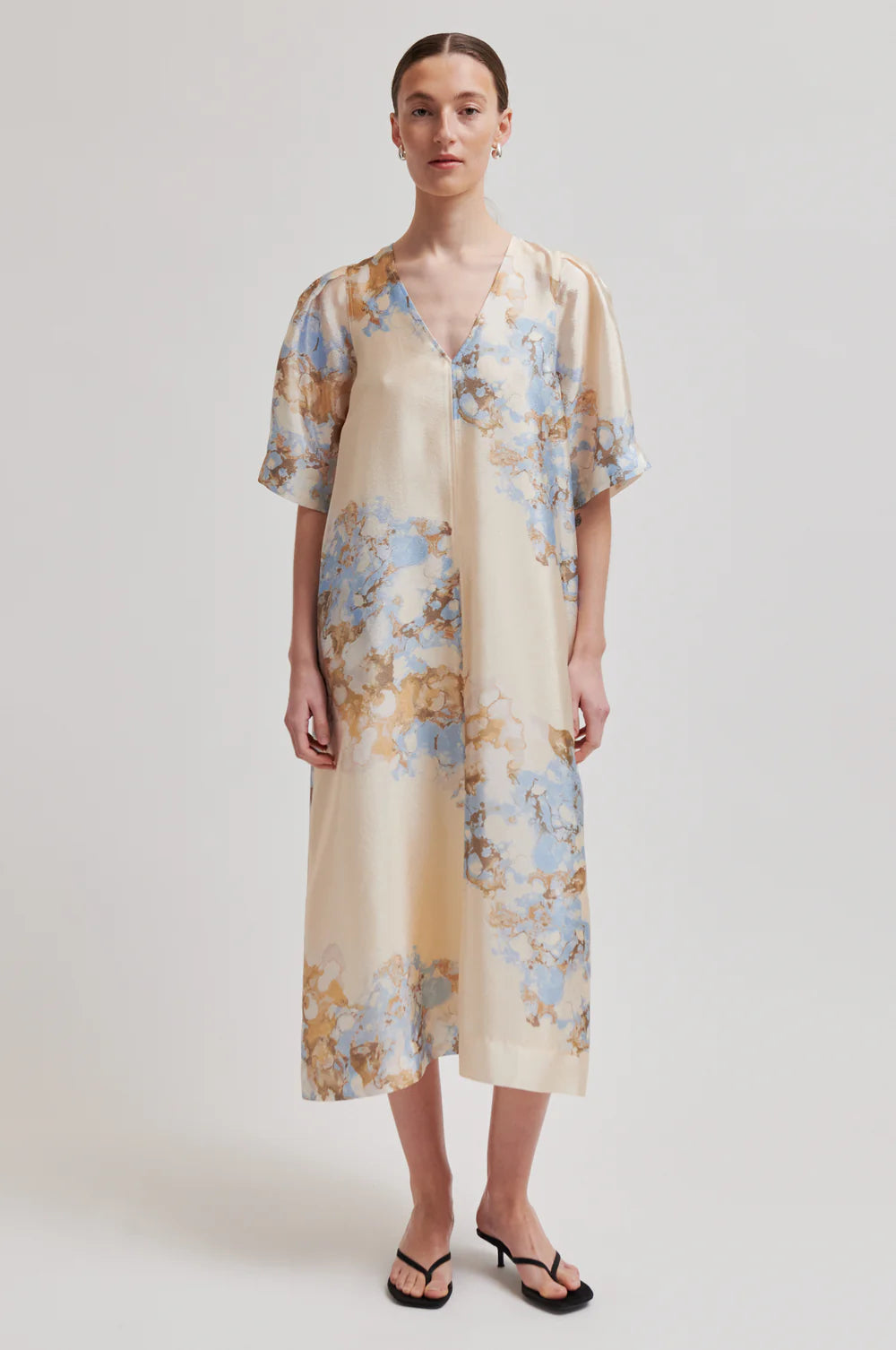 Woman wearing a floral dress with a plain background