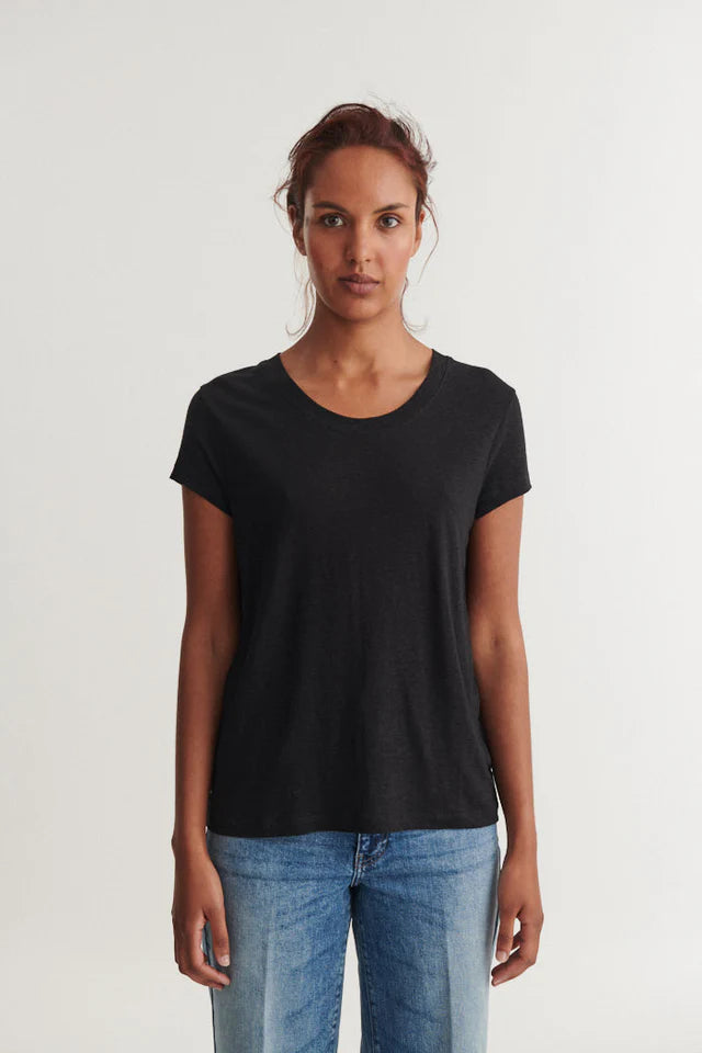 Woman wearing a black t-shirt and blue jeans on a white background
