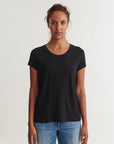 Woman wearing a black t-shirt and blue jeans on a white background